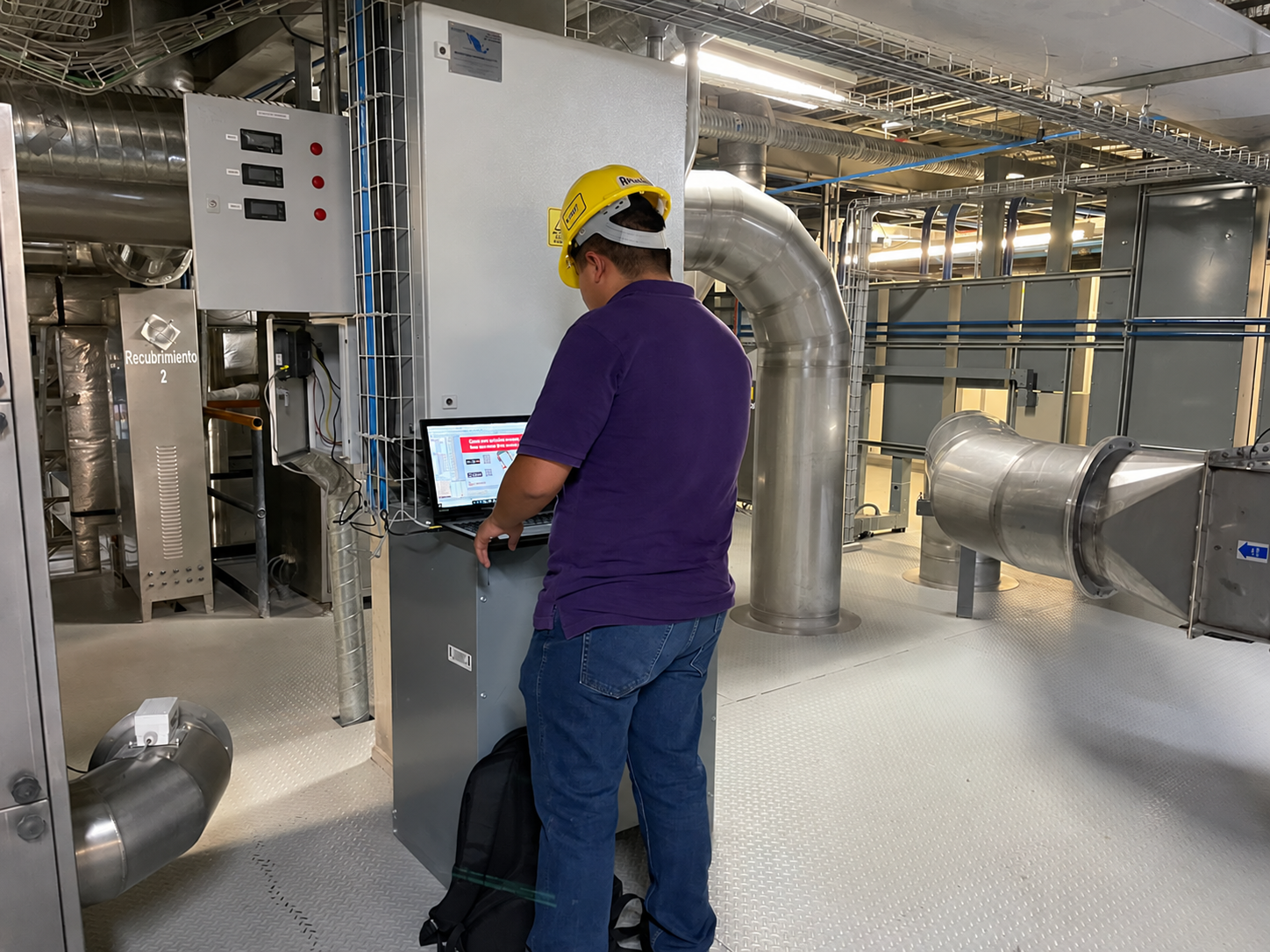 Ingeniero de DGM con casco trabajando en un sistema de control industrial